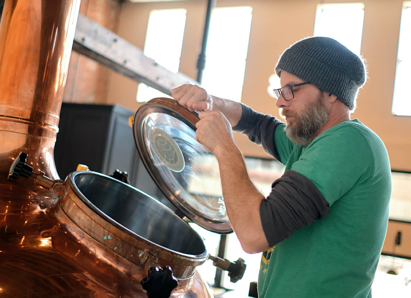 Tangled Roots brewer opening up copper brewing kettle