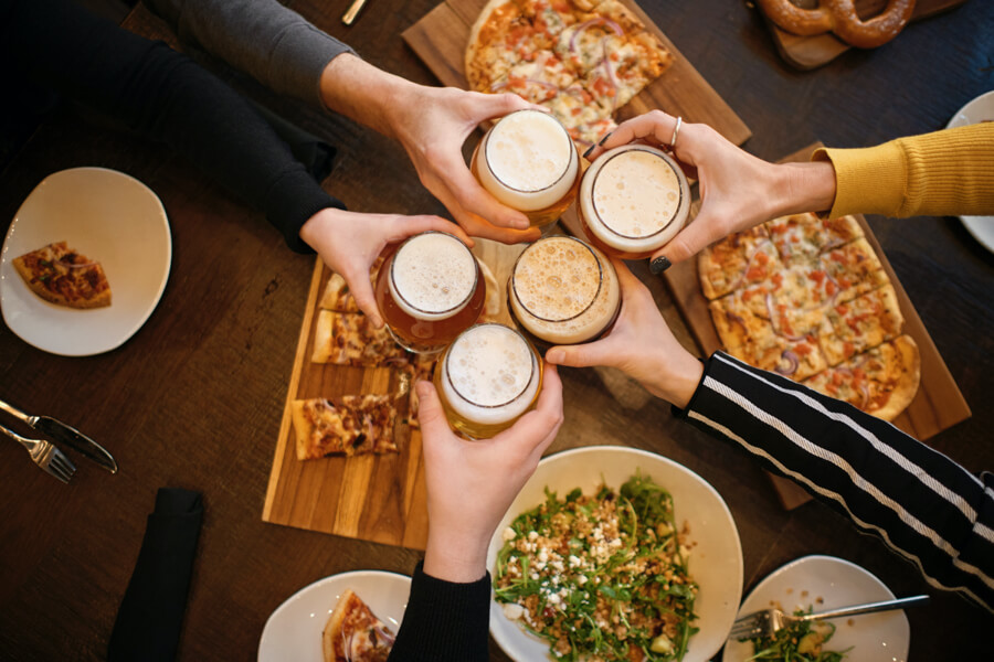 birds eye view of group of people clinking beer glasses